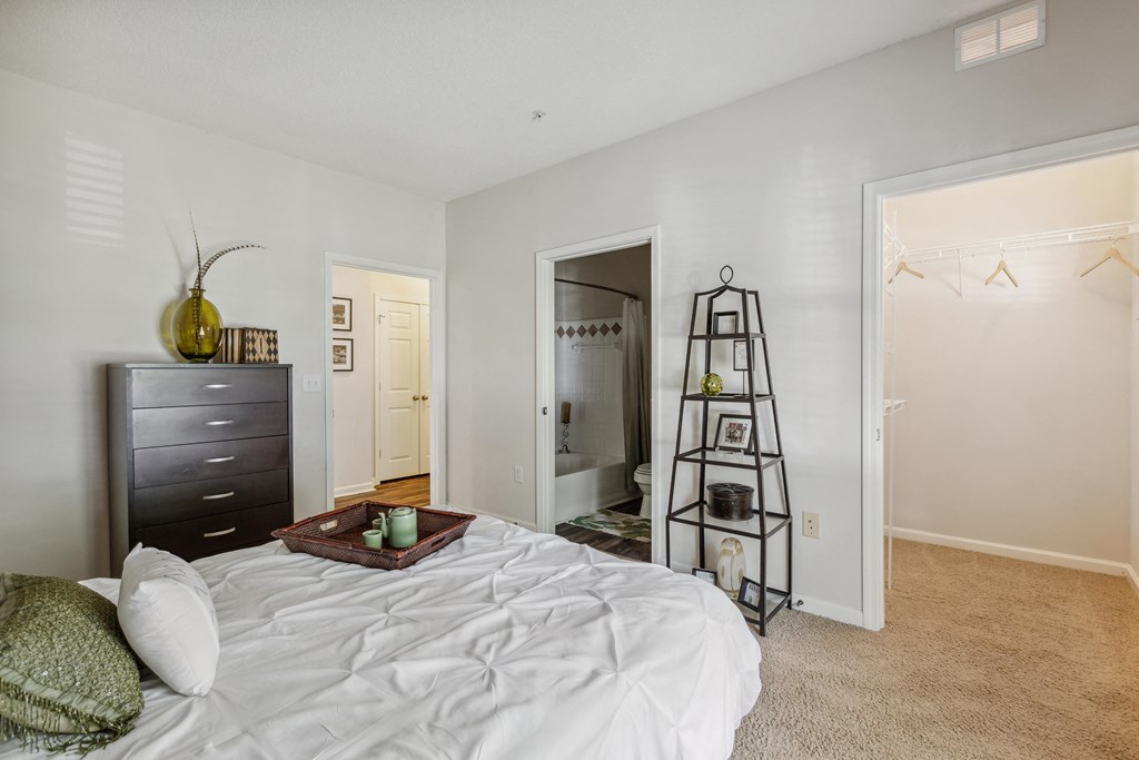 a bedroom with a white bed and a ladder in the closet