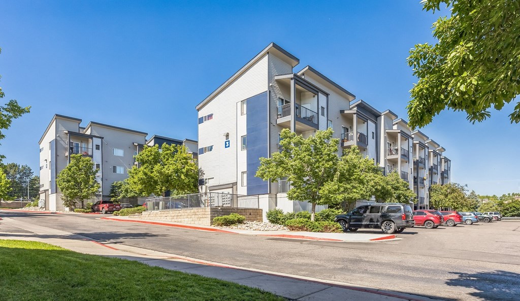 an apartment building with cars parked in front of it