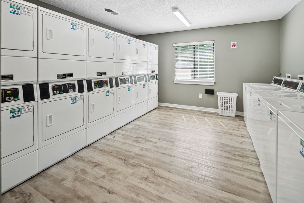 the laundry room is equipped with washer and dryer machines and a window