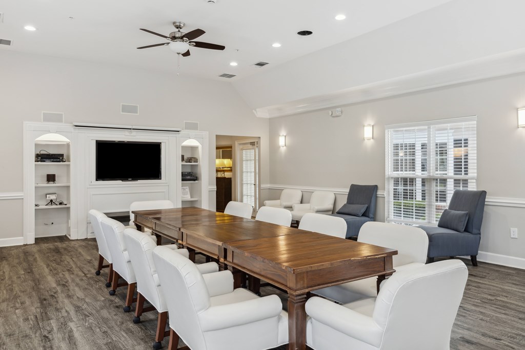 a large dining room with a wooden table and white chairs
