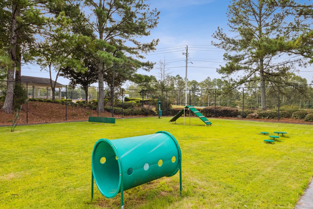 a park with a green playground and a swing set