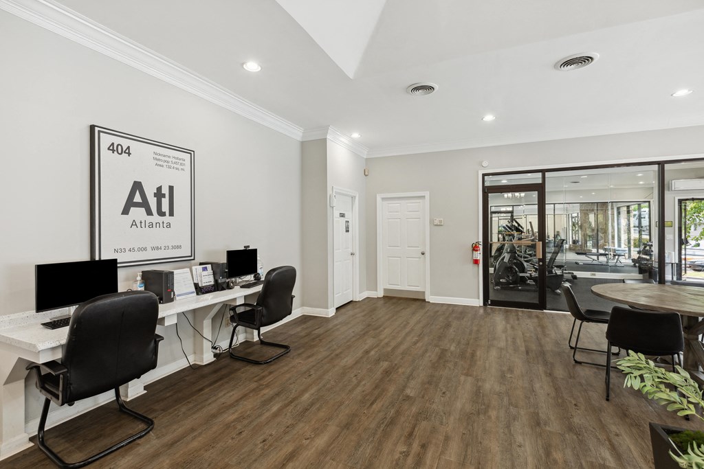 a white office with desks and chairs and a door to a store
