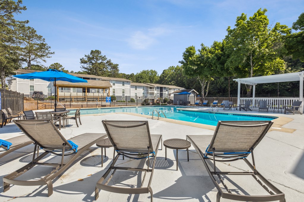 our apartments have a swimming pool with chairs and umbrellas