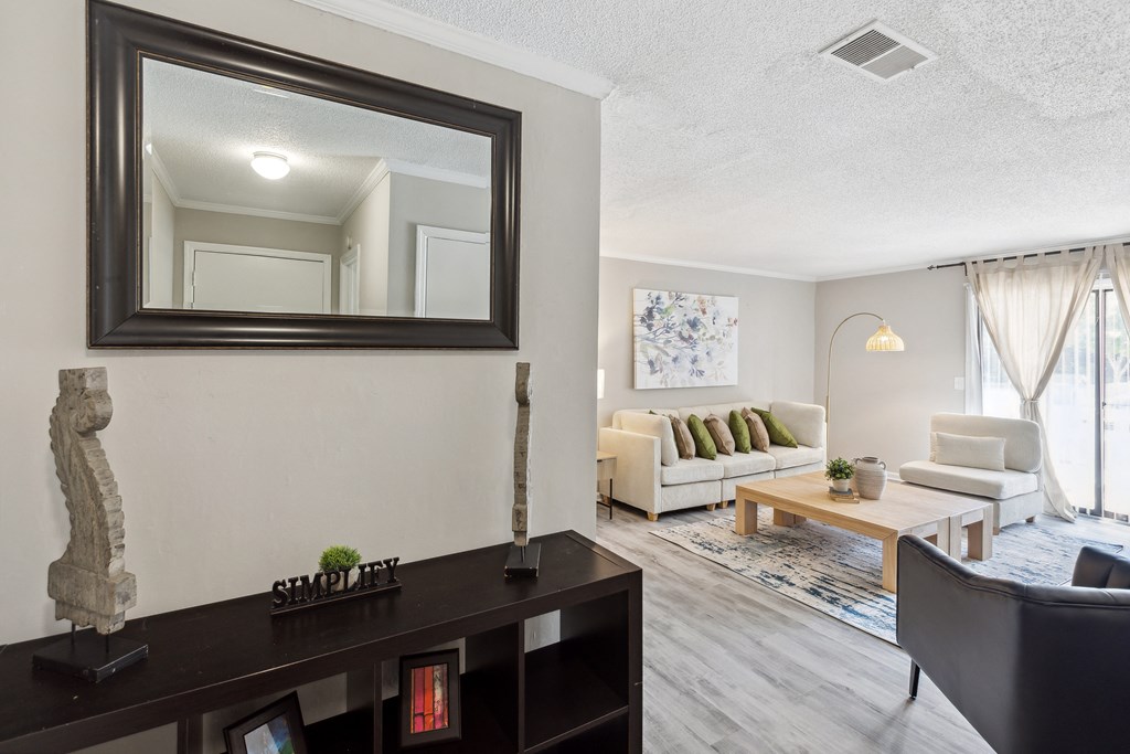 a living room with a mirror and a couch and a table