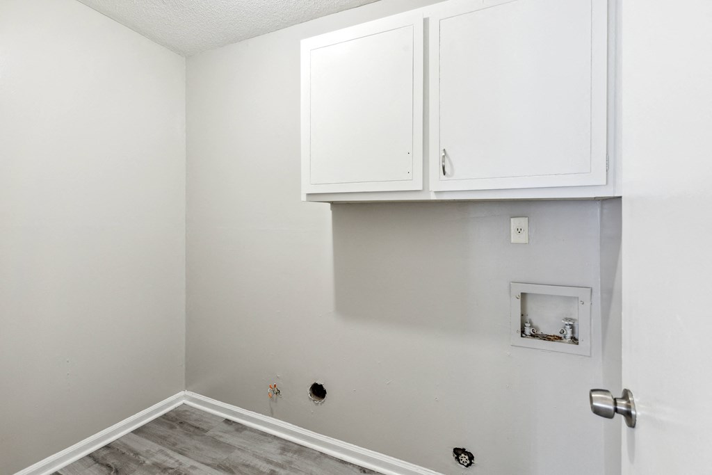 an empty room with white cabinets and white walls and a white electrical outlet