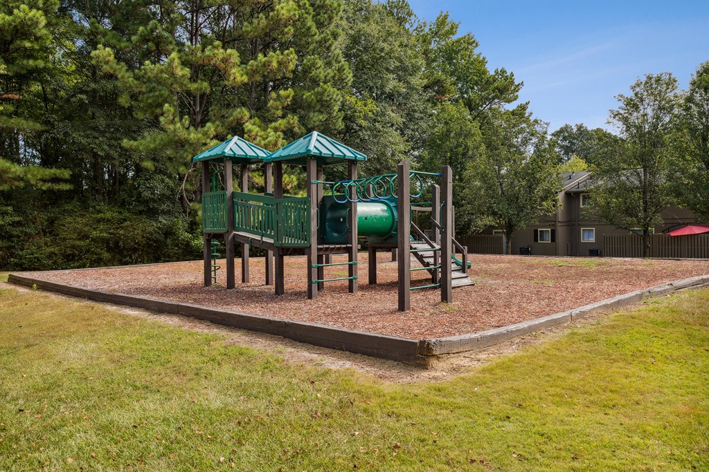 A playground with a green roof and a slide.