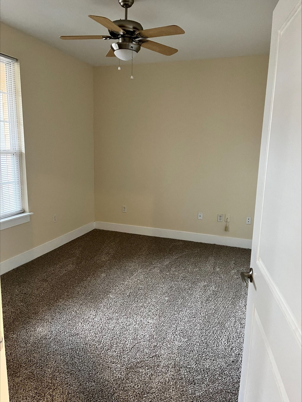 a room with a carpeted floor and a ceiling fan