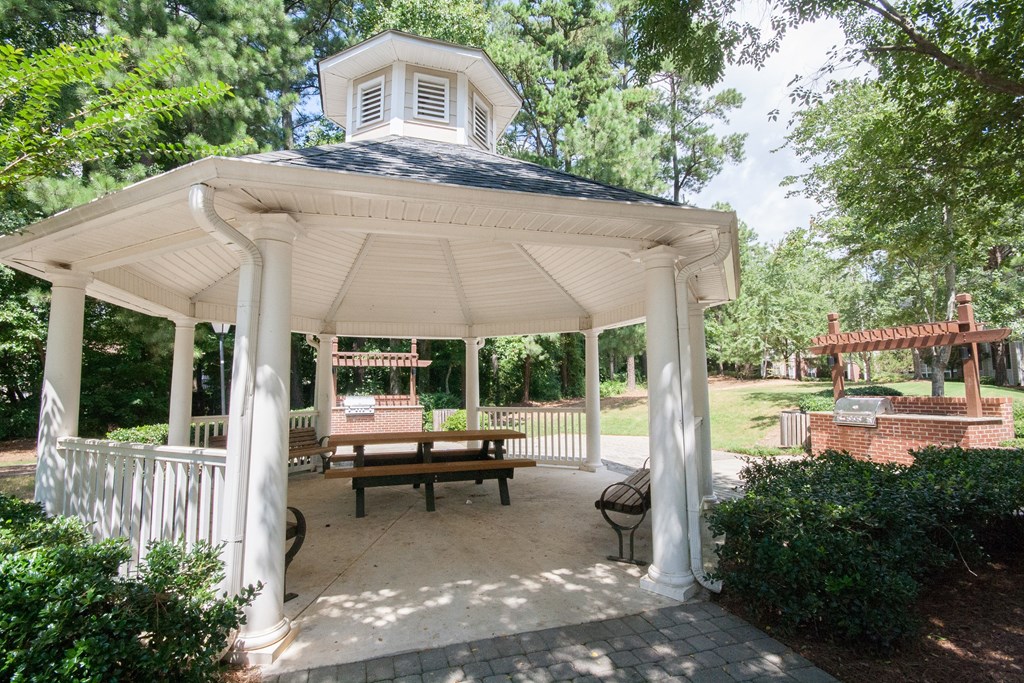 a white gazebo with a table and chairs on it