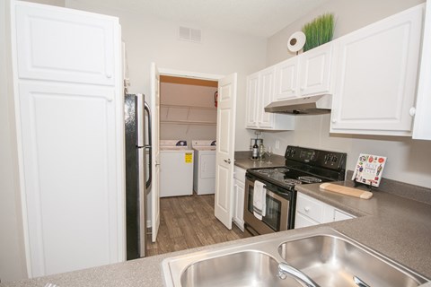 A kitchen with white cabinets and a black stove top.