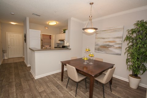 A dining room with a wooden table and chairs.