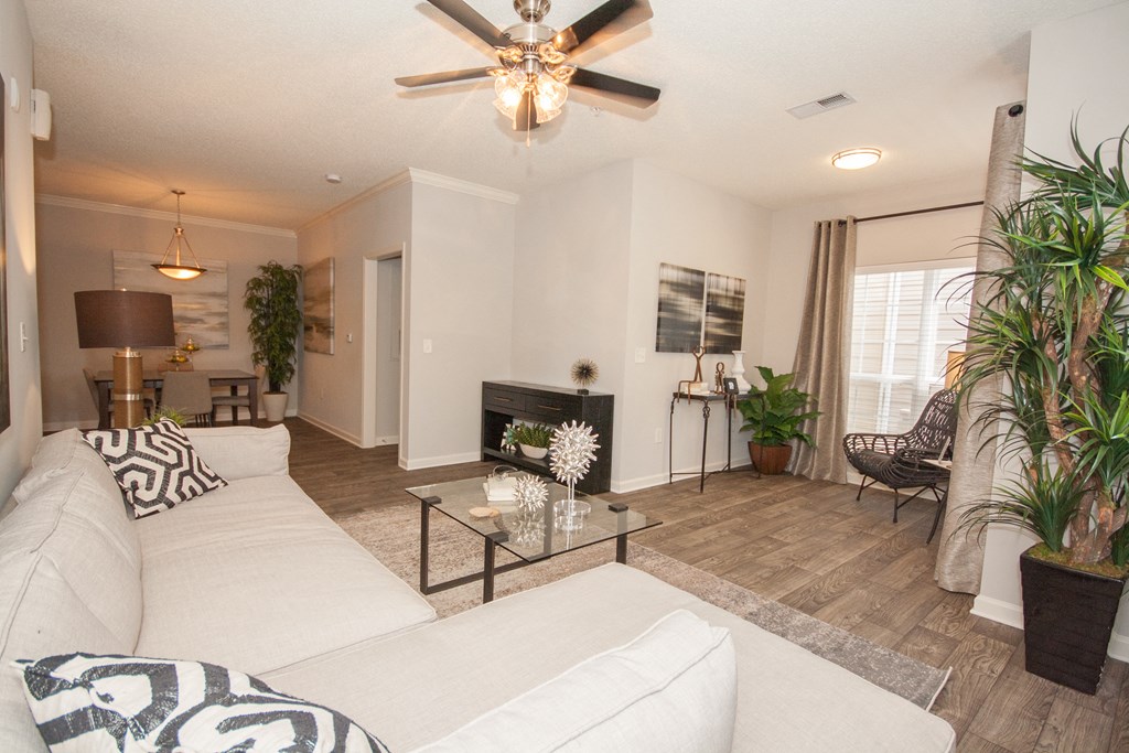 a living room with a white couch and a ceiling fan
