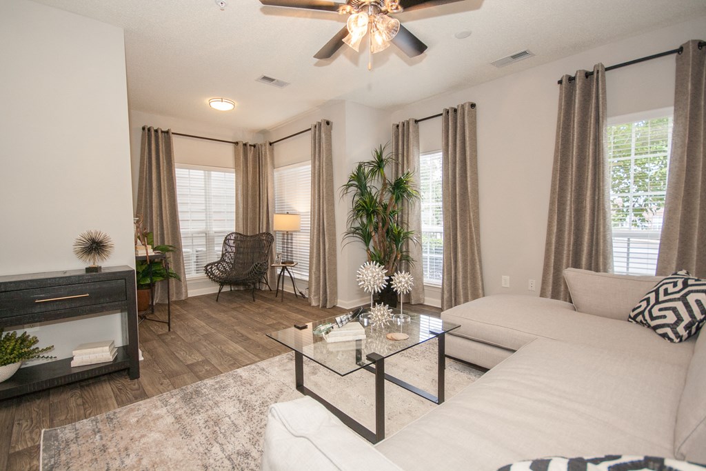 a living room with a white couch and a glass coffee table