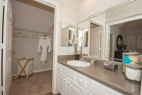 A bathroom with a white robe hanging on the wall.