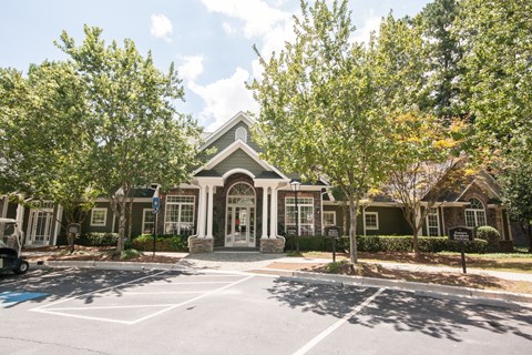 A building with a grey roof and white trim is surrounded by trees.