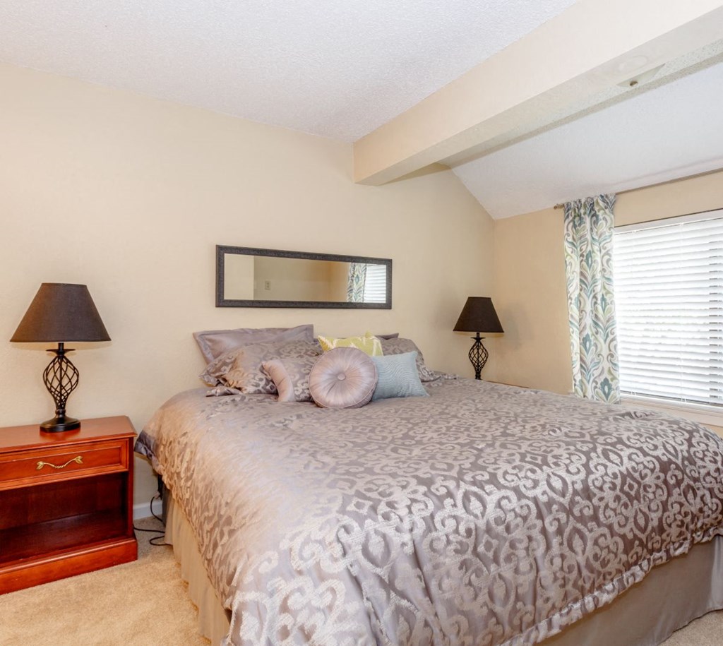 a bedroom with a large bed next to a window