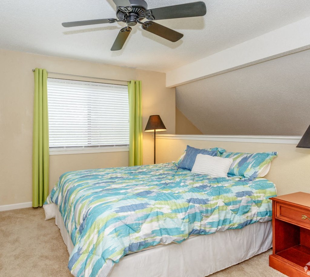 a bedroom with a bed and a ceiling fan