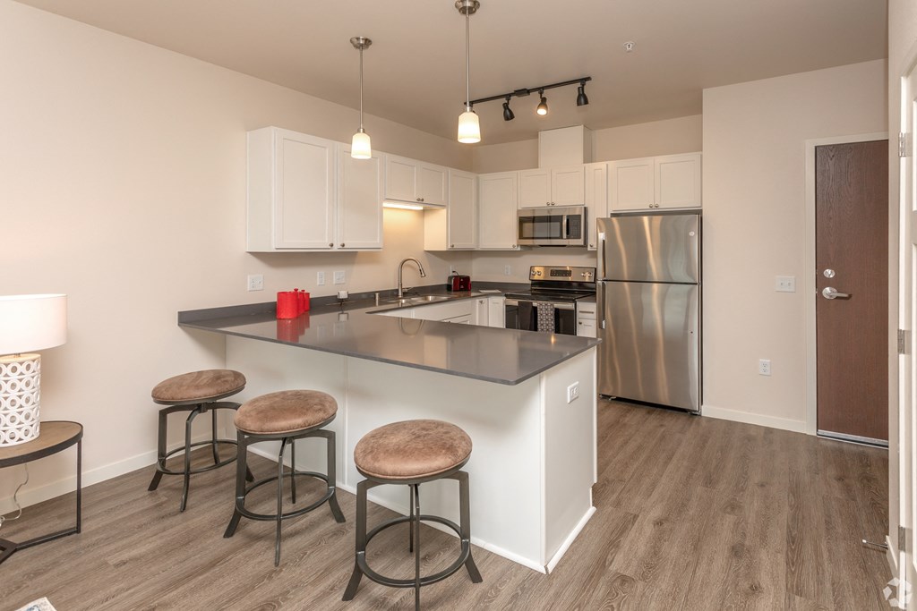 a kitchen with a large island with three stools