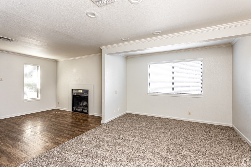 a living room with hardwood floors, carpent, and a fireplace