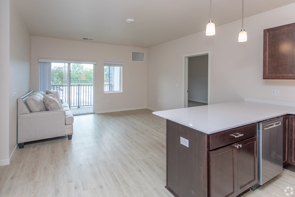 an open kitchen and living room with a couch and a refrigerator