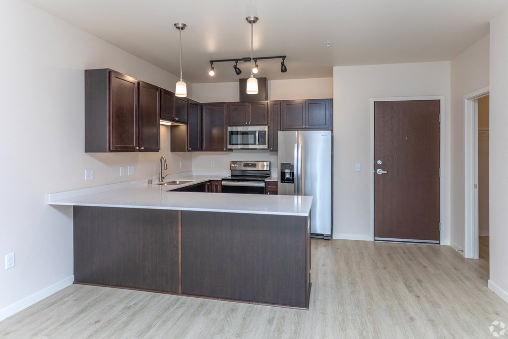 a kitchen with wooden cabinets and a white counter top