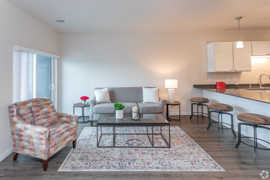 a living room with a couch and a table and a kitchen