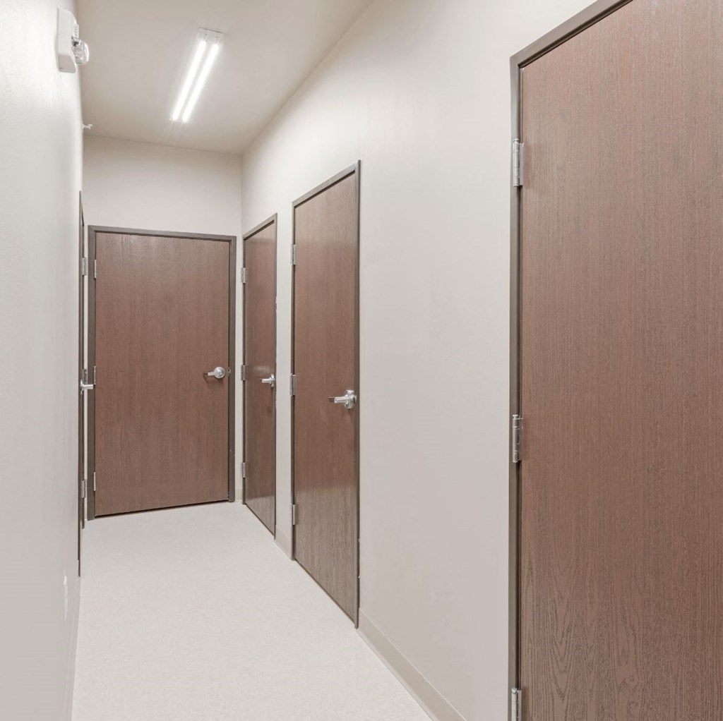 a row of wooden doors in a corridor of a building