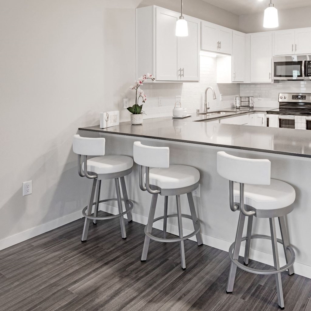 a kitchen with a counter top and three stools