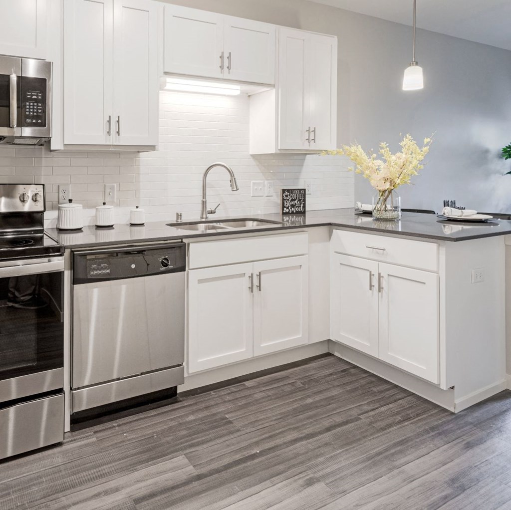 a kitchen with white cabinets and stainless steel appliances