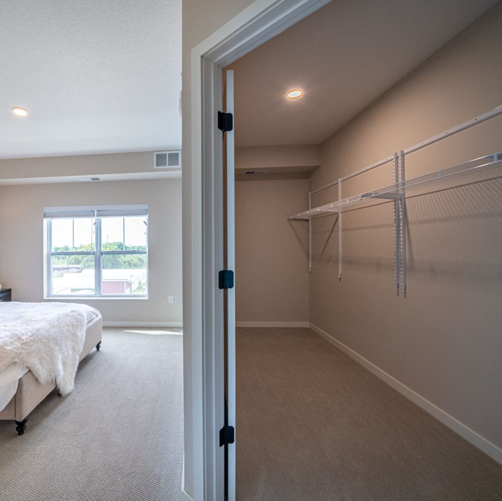 the master bedroom has a walk in closet and a large bed