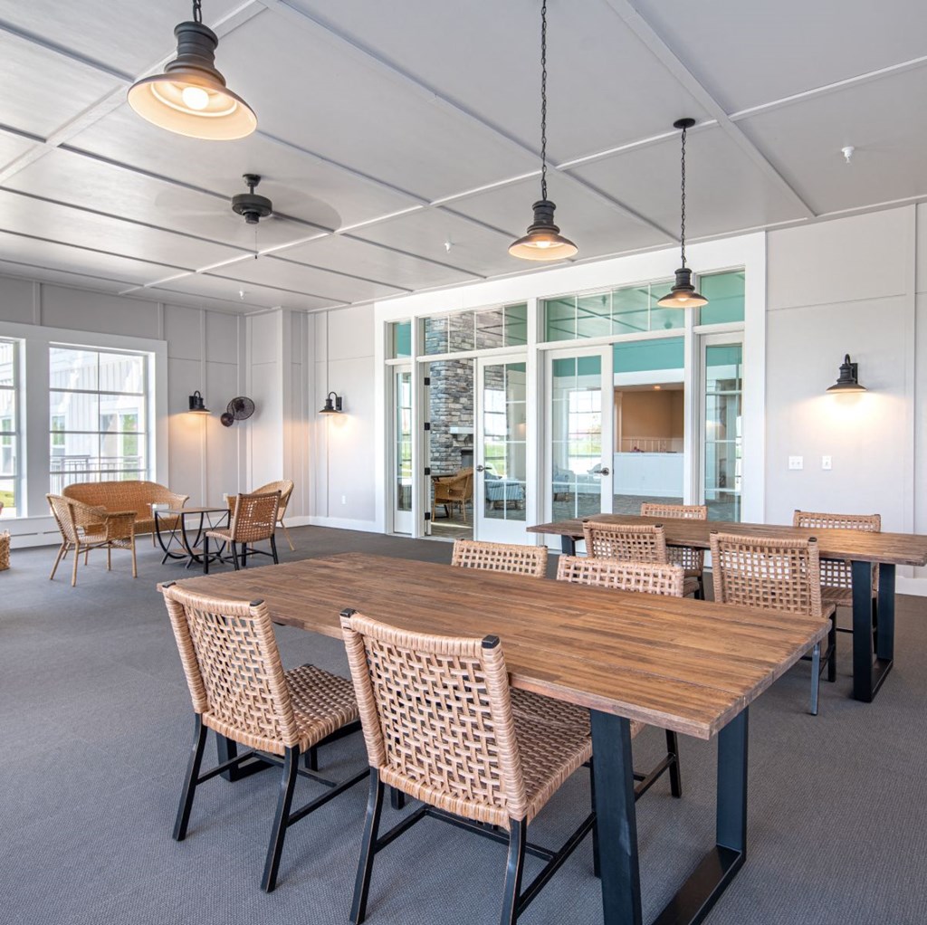 a large communal table with chairs in a room with windows