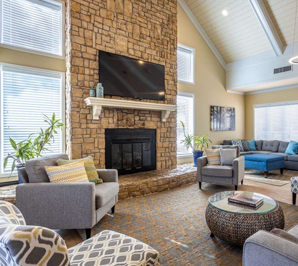stone fireplace surrounded by comfortable looking chairs