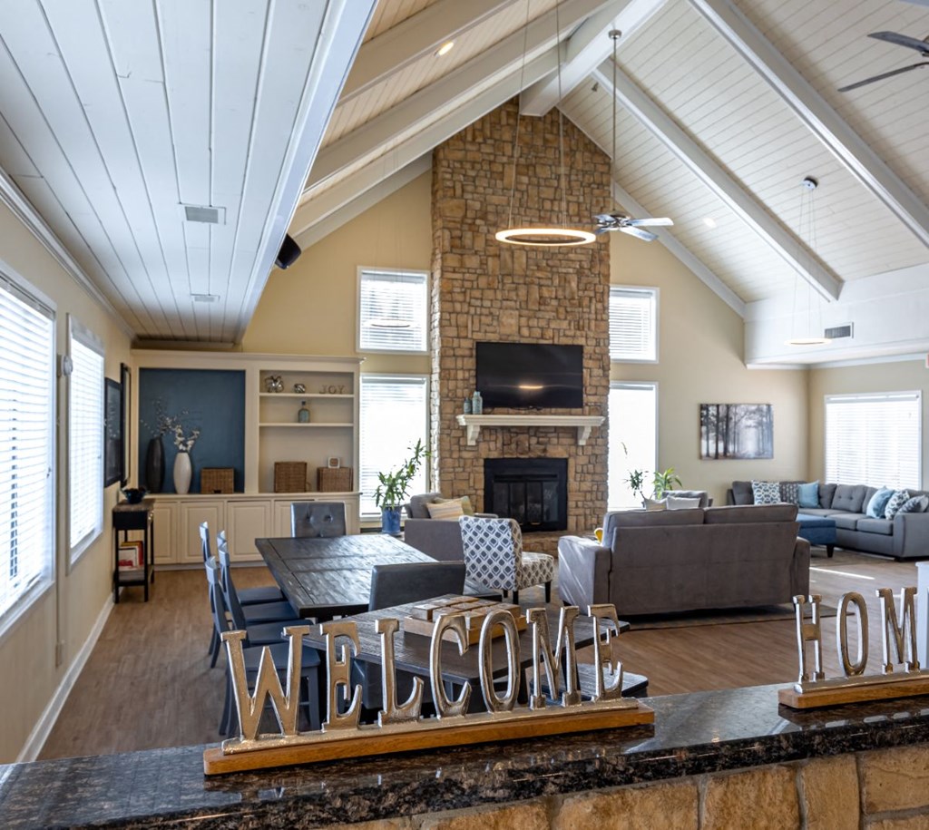 large room with high ceilings, couches, and a television