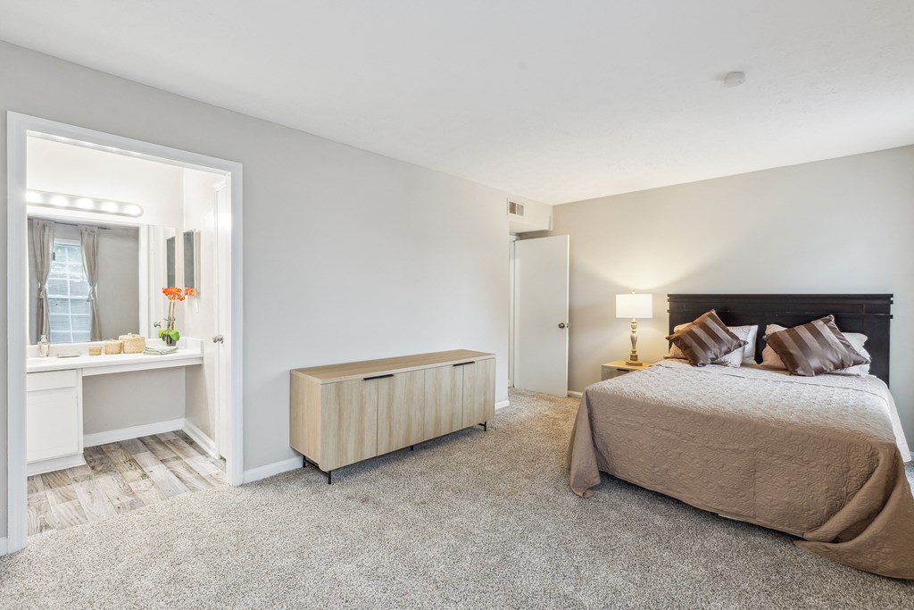 a bedroom with a bed and a desk and a mirror