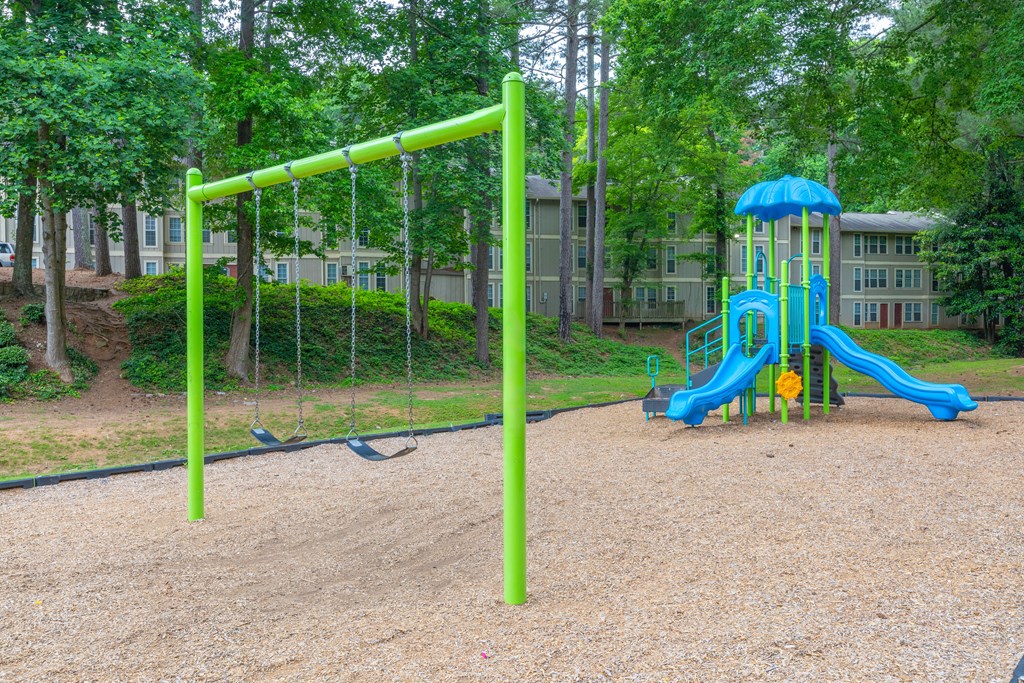 a playground with a blue and yellow swing set