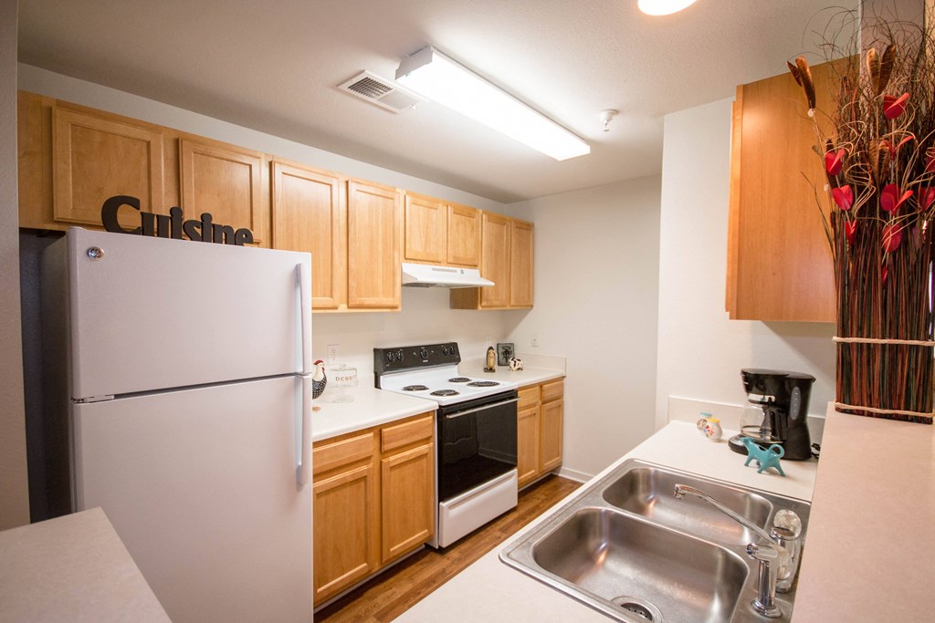 a kitchen with white appliances and wood cabinets