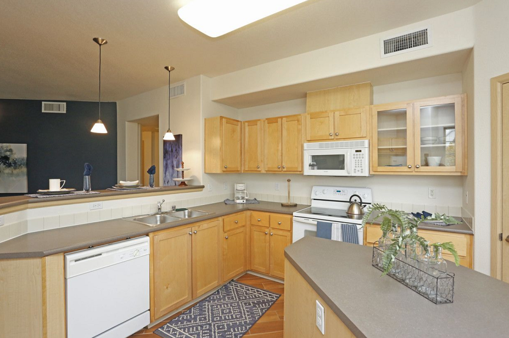 a kitchen with white appliances and wooden cabinets.