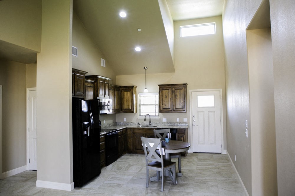 a kitchen with black appliances and a table with chairs
