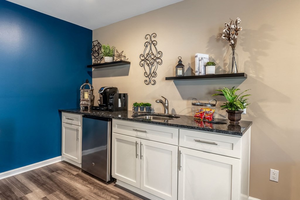 a kitchen with a blue wall and white cabinets