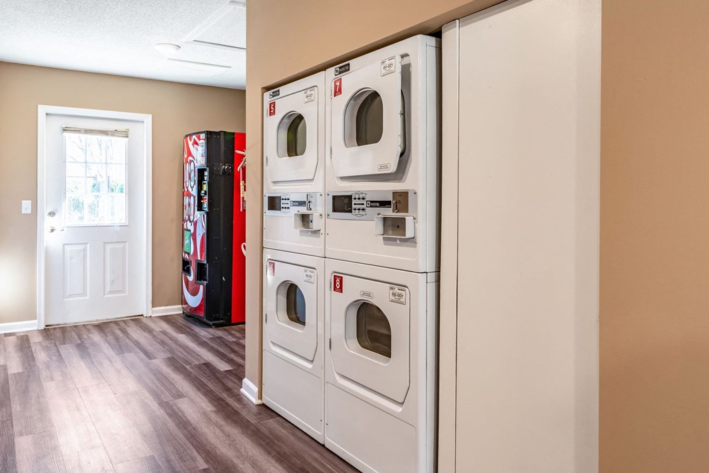 a washer and dryer in a laundry room with a vending machine