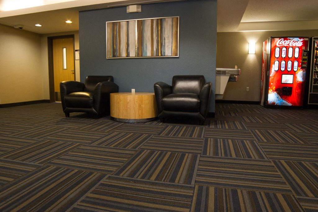a room with two chairs and a coke vending machine