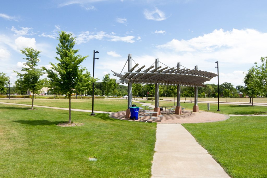 a picnic shelter in a park with grass and trees