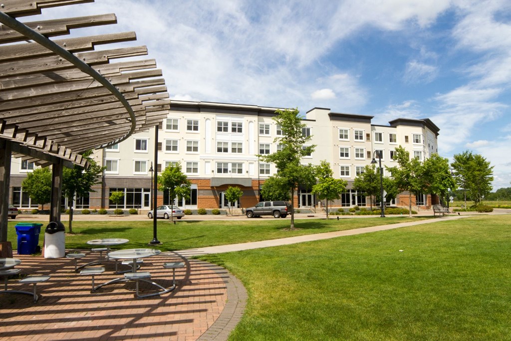 a park with tables and chairs in front of a building