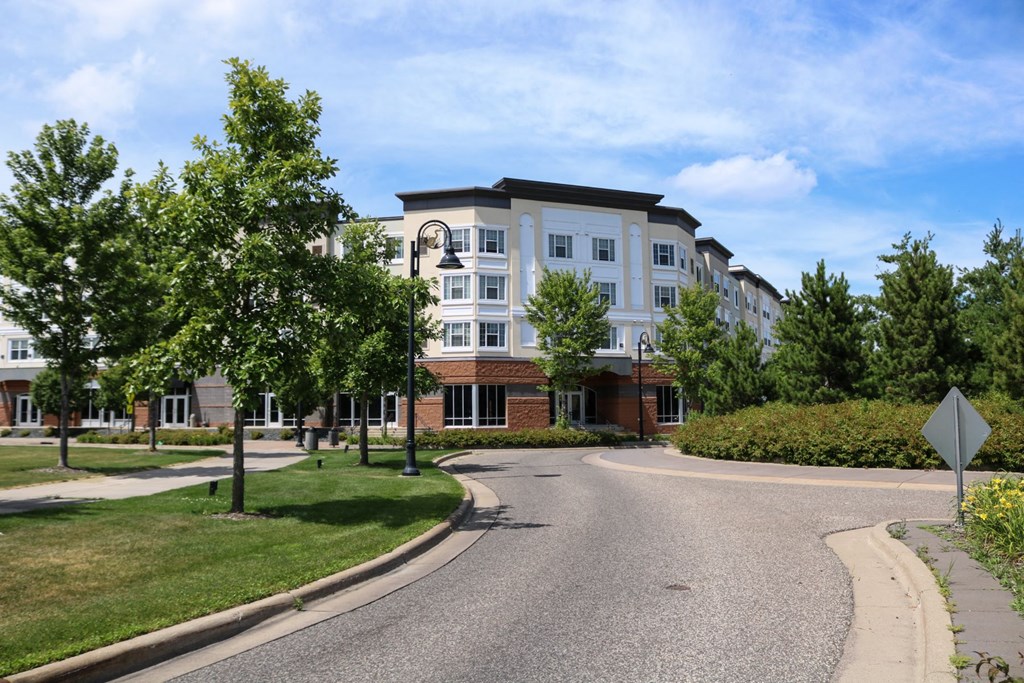 an apartment building on the corner of a street with trees