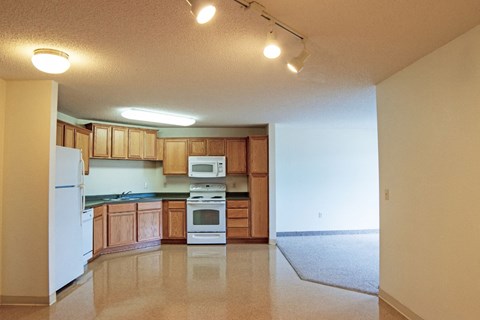 an empty kitchen with wooden cabinets and white appliances