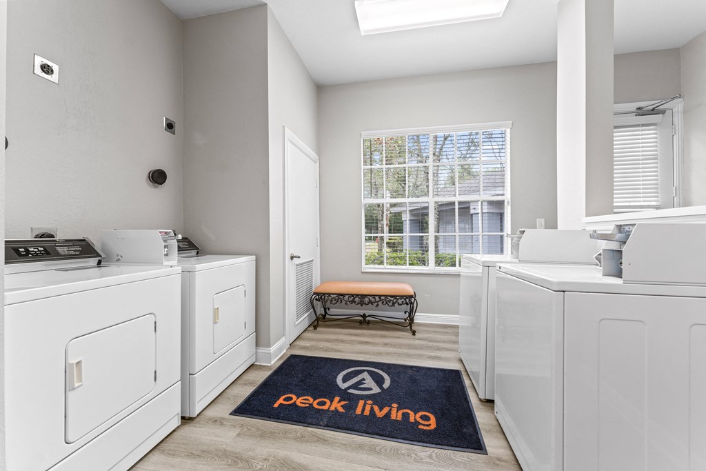 a washer and dryer in a white laundry room with a window