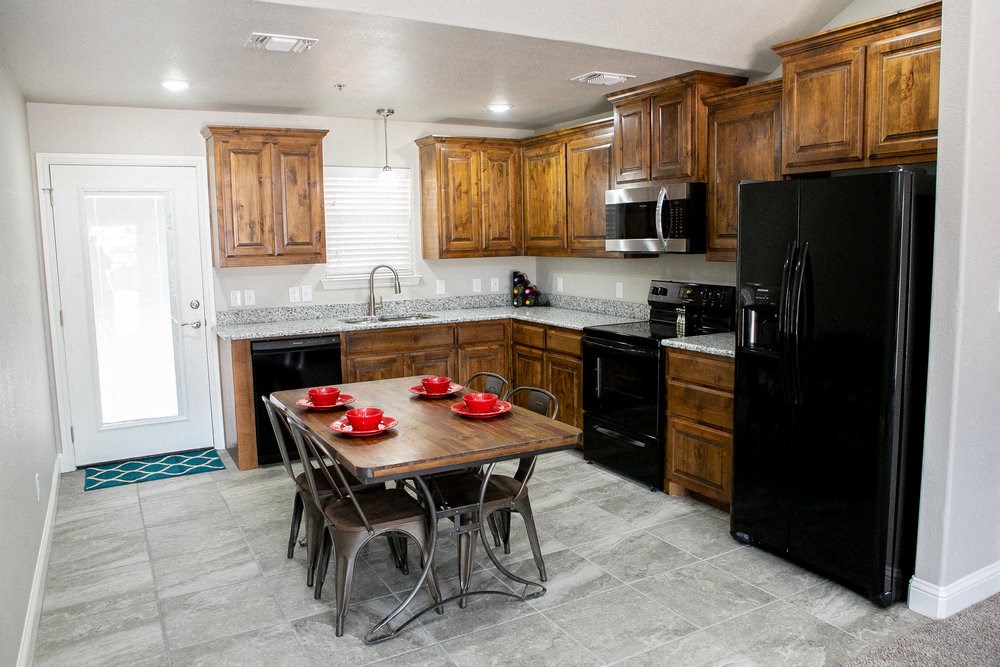a kitchen with black appliances and a table with chairs