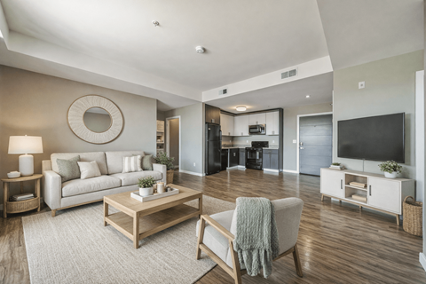 A modern living room with a white couch, a wooden coffee table, and a flat-screen TV.