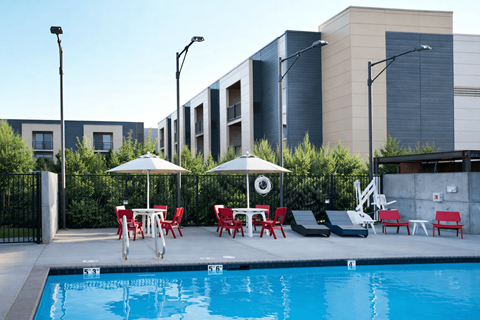 Pool deck with lounge chairs and umbrellas at Lofts at Innovation Center Apartments, Washington