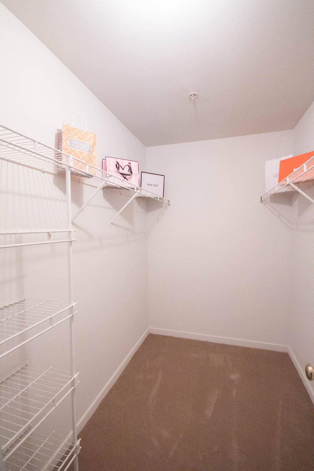 a room with white walls and a closet with shelves