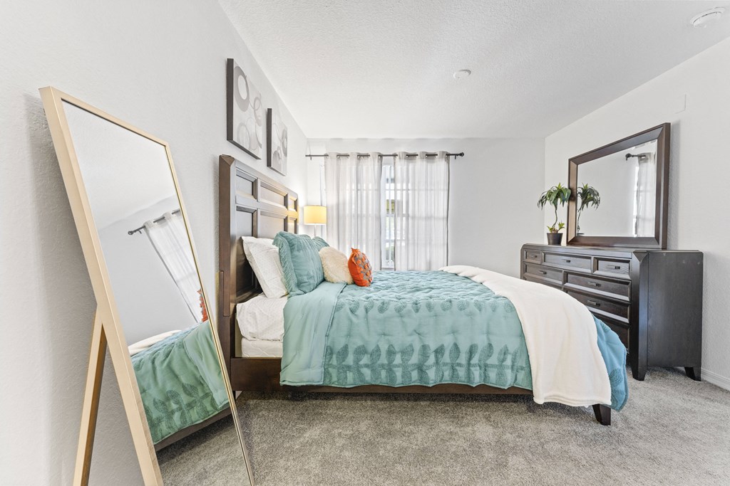 a bedroom with a bed and a mirror